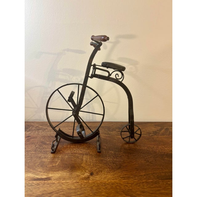 This antique iron sculpture is modeled after a classic big wheel (penny-farthing) bicycle, executed with impressive...