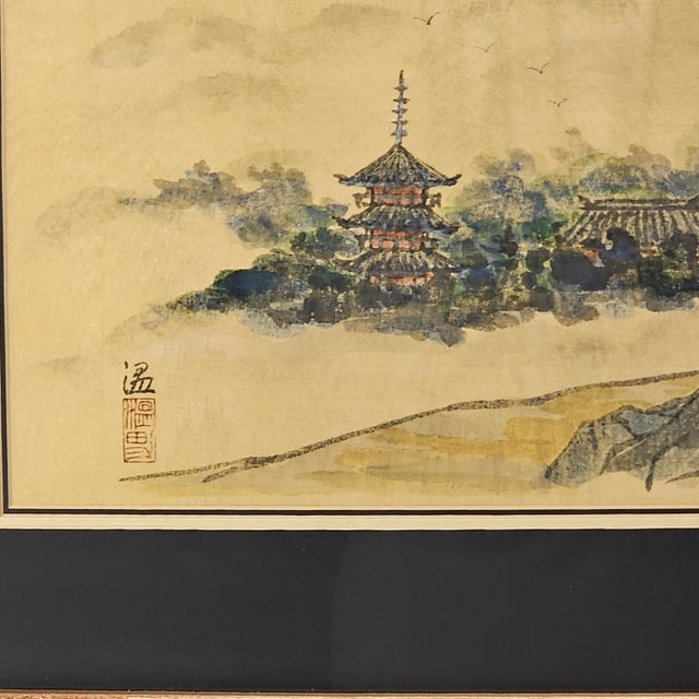 Executed in ink and color on luminous moiré silk, this East Asian landscape depicts a pagoda and temple complex emerging...