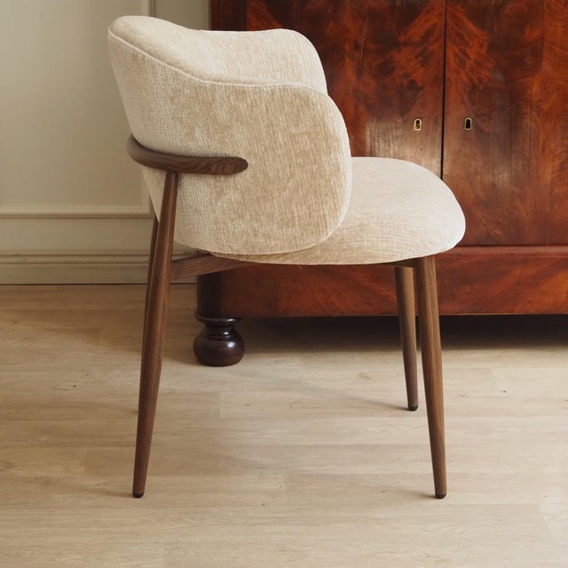 This stylish designer chair is a newly produced piece of seating furniture with a fully upholstered body consisting of a...
