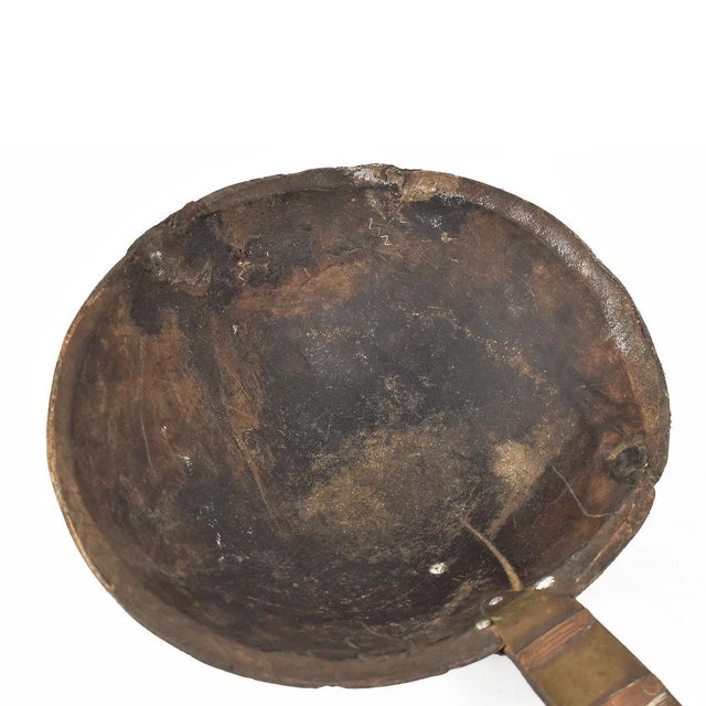 This wooden spoon or scoop crafted by the Tuareg people boasts intricate metal designs characteristic of their artistic...