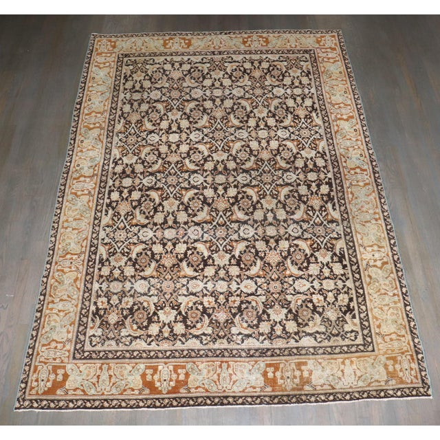 An early 20th-century Indian Agra Rug with an all-over herati design on a dark brown ground