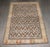 An early 20th-century Indian Agra Rug with an all-over herati design on a dark brown ground