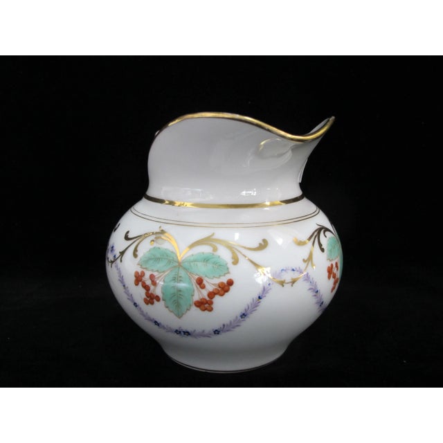 Sweet vintage porcelain pitcher. White with scrolling green leaves and red berries, all accented in gold. Measures 6" x 4...