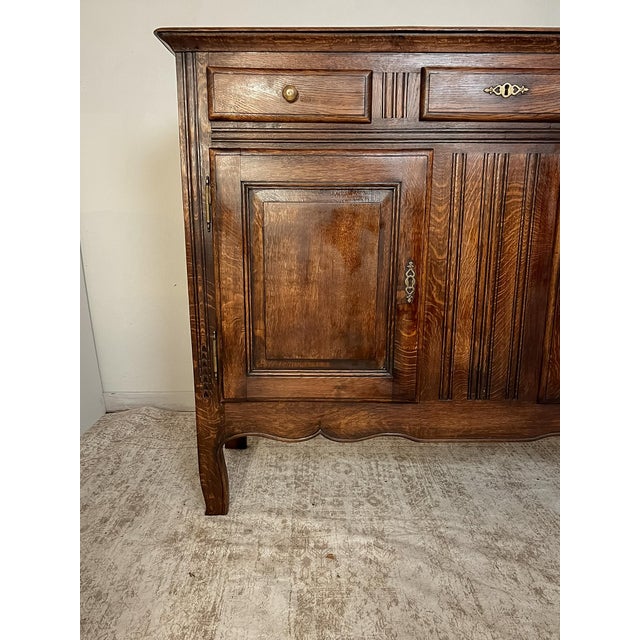 Handcrafted in France around 1900, this antique Provincial buffet showcases the enduring beauty of solid oak construction...