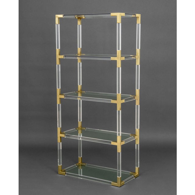 Jonathan Adler Lucite and Brass Etagere, with four glass shelves and label to base. 66.25" H x 30" W x 16" D. Provenance:...