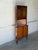 This display cabinet features a space-saving corner profile with patterned glass upper doors and solid lower doors. An...