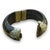 This bracelet showcases a striking design with intricate engravings on a dark, polished base. The detailed floral patterns...