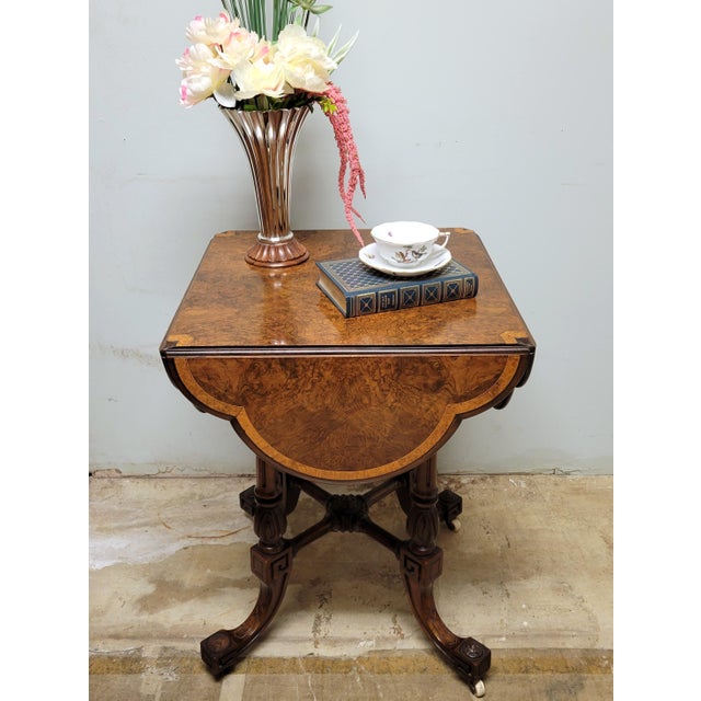 A beautifully crafted antique English cloverleaf table, showcasing dramatic burled walnut veneers with a warm, lively...