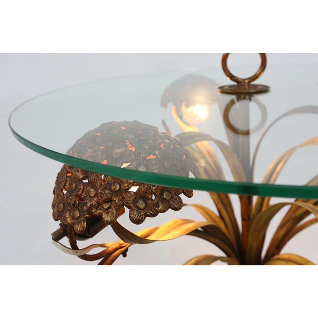 A sculptural and atmospheric French coffee table from the 1950s, combining metal craftsmanship with a circular glass top...