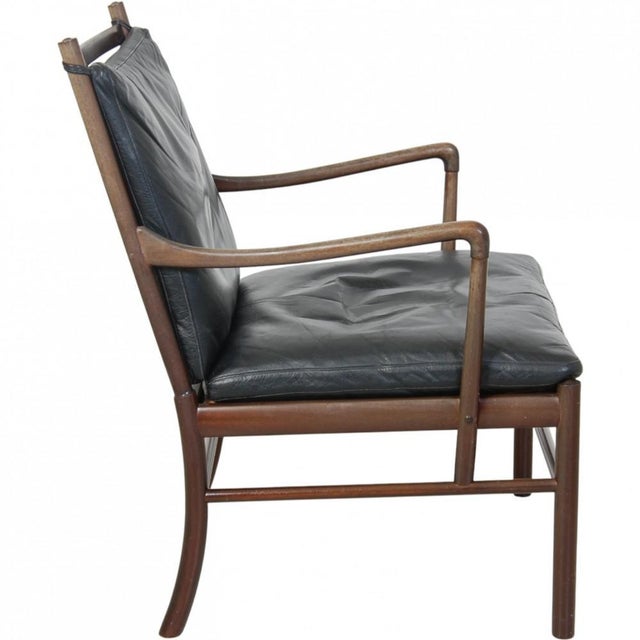 Ole Wanscher Colonial chair with a frame of lacquered mahogany and cushions upholstered in black leather. The chair is...