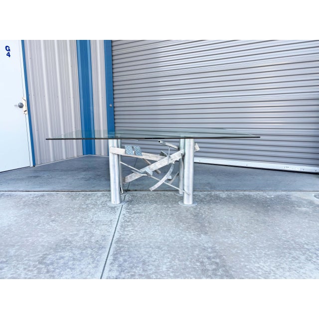 Modern Glass Dining Table with Aluminum Cityscape Base This striking modern dining table features a sleek glass top that...