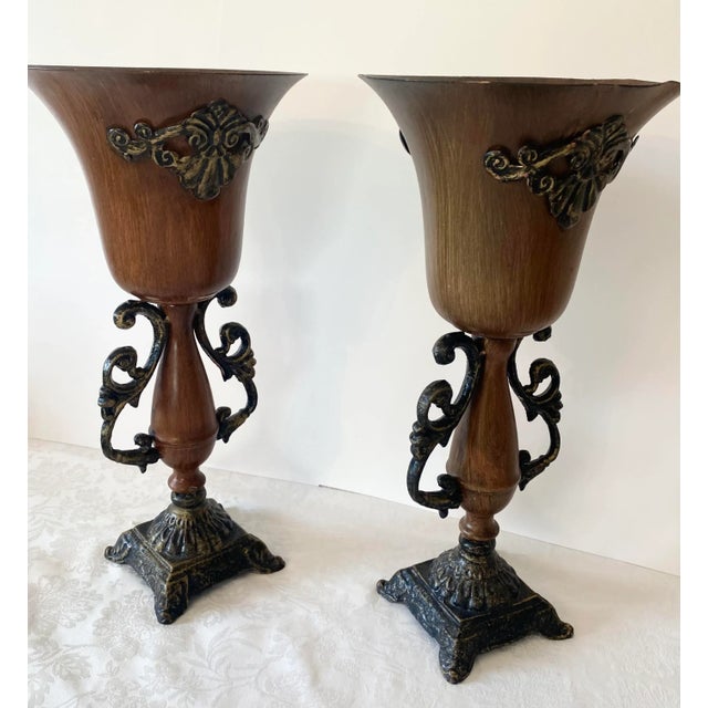 Vintage Pair of Neoclassical Borghese Style Metal Vases. These vases feature an exquisite frame with handles and a...