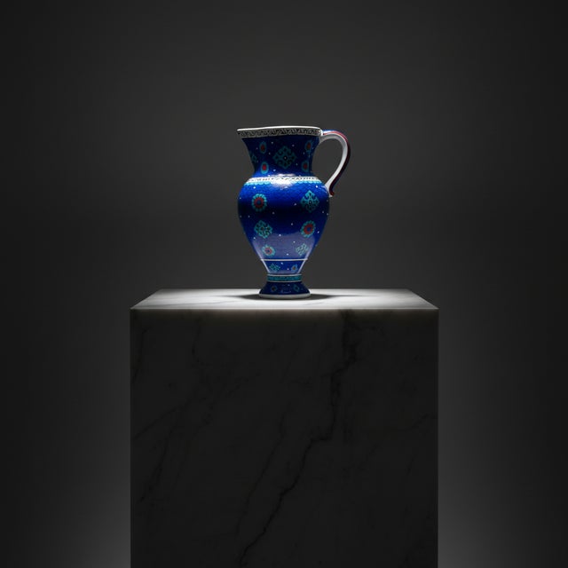 A Masterpiece from the Depths This Handmade Ceramic Pitcher stands out with its intense color and tactile pattern....