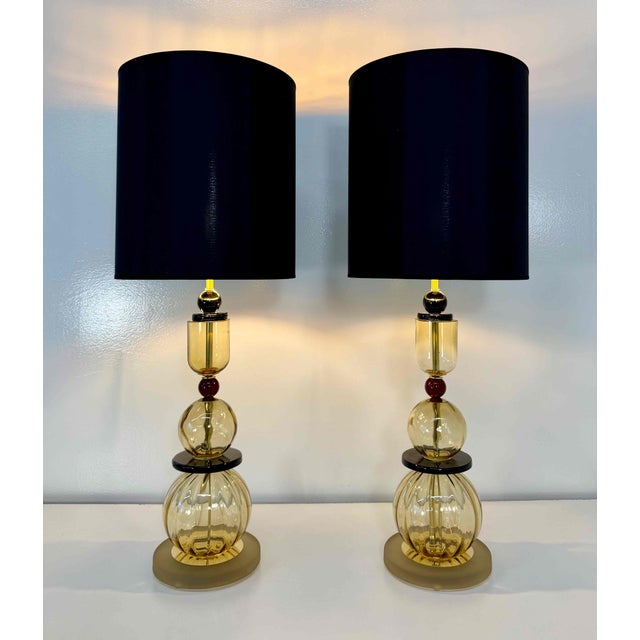 Elegant pair of table lamps produced in Italy and crafted from stacked Murano glass elements. The sculptural composition...
