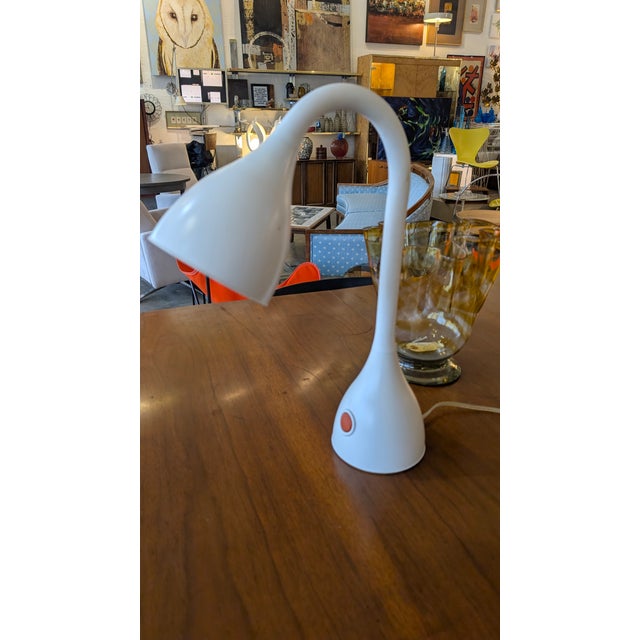 This striking table lamp is a masterclass in minimalist retro design. Featuring a seamless, organic silhouette, it evokes...