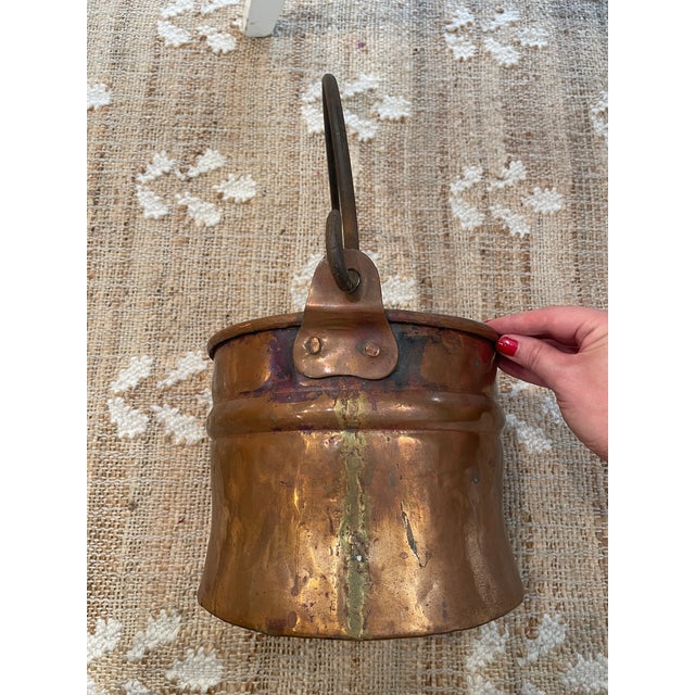 This antique handcrafted copper bucket features unique riveted dovetail details, making it a special addition to any...