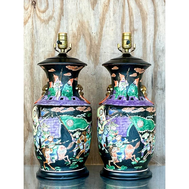 An exceptional pair of vintage Chinoiserie ceramic table lamps, beautifully hand decorated with richly detailed scenes...