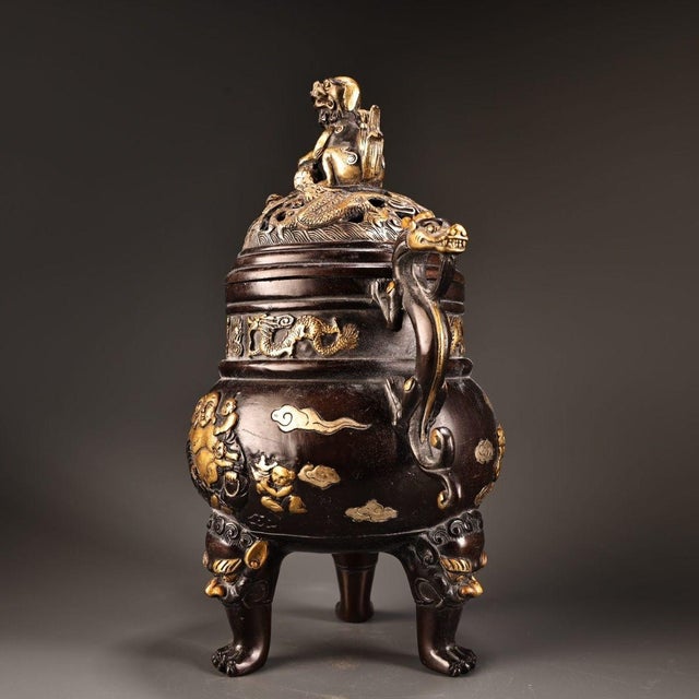 An exceptional solid-copper incense burner finished in rich gilt gold-and-silver, adorned with fine high-relief carving....