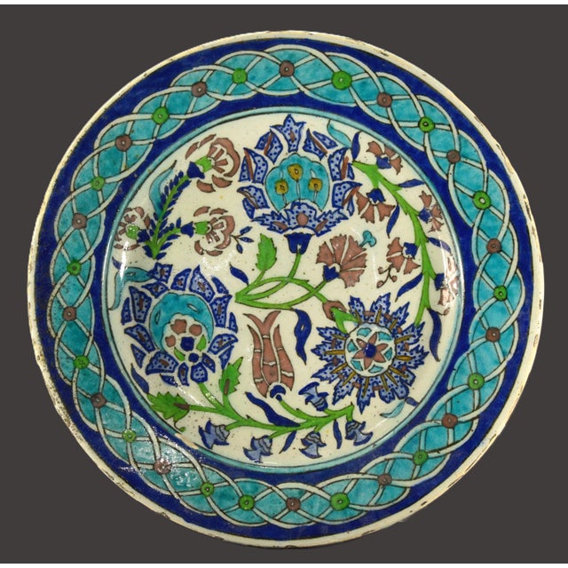A stunning antique earthenware plate Characteristic Iznik pottery design, featuring hand painted floral and geometrical...