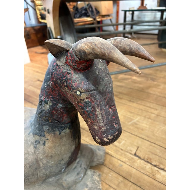 Striking and rich in character, an antique rare primitive Thai sculpture of a ram, having vestiges of original red and...