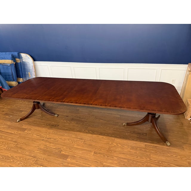 This is a Traditional Banded Mahogany Dining Table by Leighton Hall Furniture. It features a field of swirly crotch...