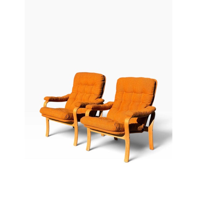 OVERVIEW A matched pair of mid-century modern bentwood lounge armchairs, freshly reupholstered in a warm burnt orange...