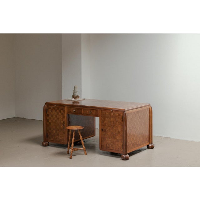 Art deco writing desk produced in France around 1930. This 2 sided desk has a monumental base with a wooden inlay finish...