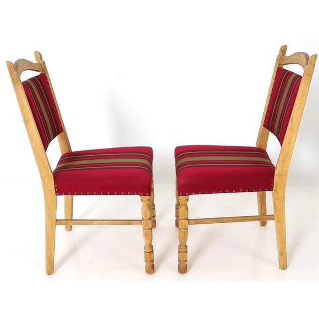 An understated and well made set of 4 Danish mid century modern dining chairs. Carved oak frames and a subtle red striped...