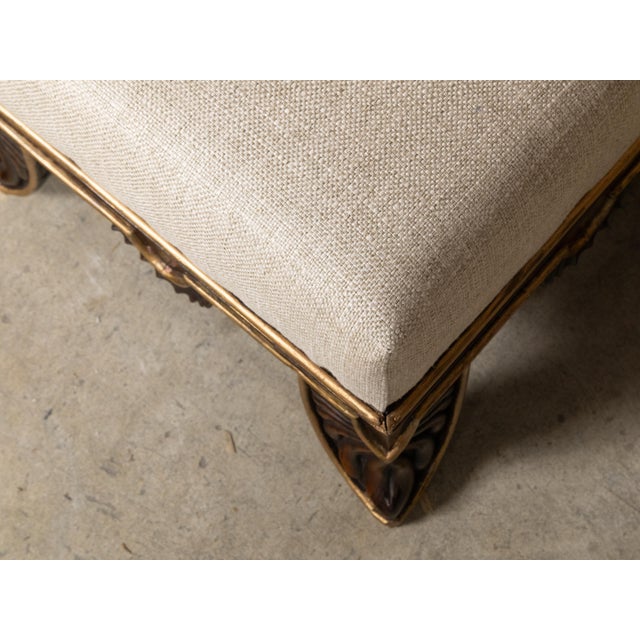 A pair of English Regency period footstools from the 19th century with carved feet, gilded accents and custom upholstery....