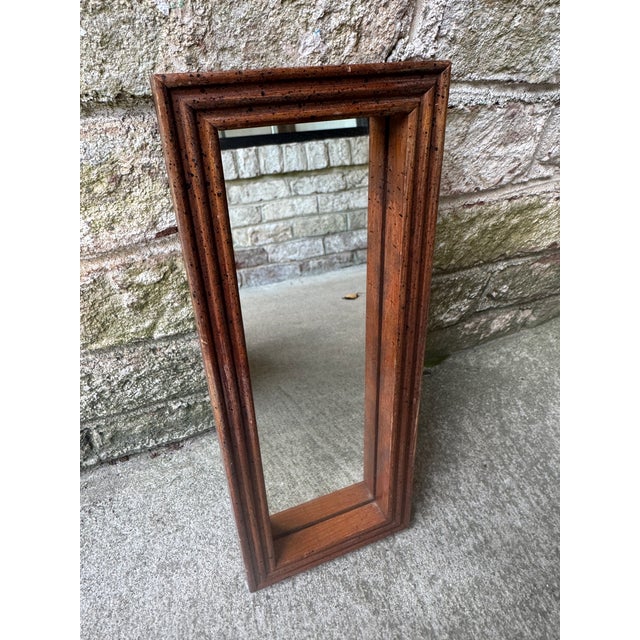 Vintage narrow rectangular wall hung mirror. This small scale wooden mirror has hardware on the back that allows you to...