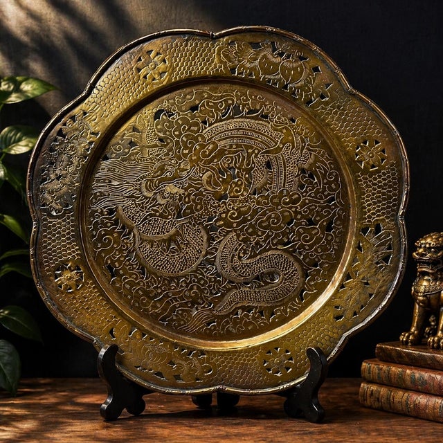 A striking vintage pierced brass dragon charger, intricately hand-worked with a dynamic imperial dragon amid swirling...