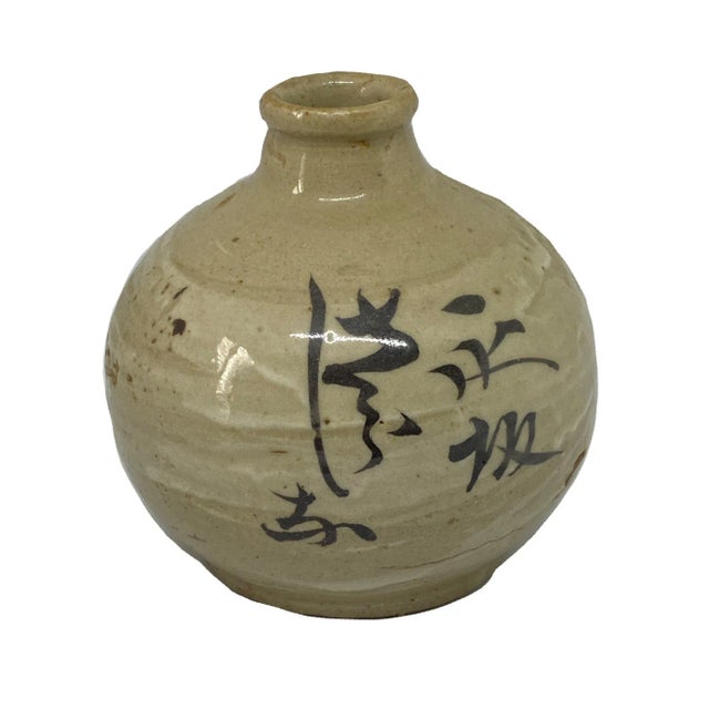 A fine Japanese 19th century ceramic bulbous vase with black underglazed calligraphy. It is roughly potted with a thick...