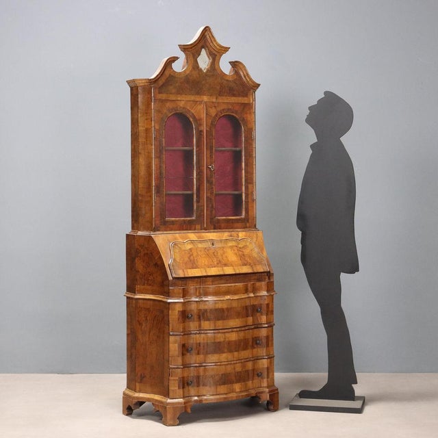 Period trumeau in walnut and walnut burl. The upper part features a pair of glass doors, two internal shelves, and a...