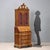 Period trumeau in walnut and walnut burl. The upper part features a pair of glass doors, two internal shelves, and a...