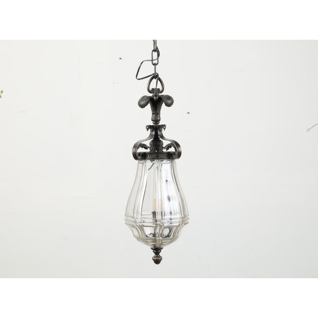 A French bronze and glass lantern from the early 20th century, with feathers and acanthus leaf motifs. Created in France...