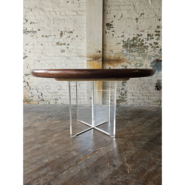 A stunning walnut and acrylic dining table by Vladimir Kagan with two leaves and drop-down acrylic support legs, used when...
