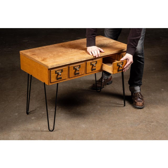 Vintage wooden library card catalog repurposed as a distinctive console or occasional table. The oak case features a...