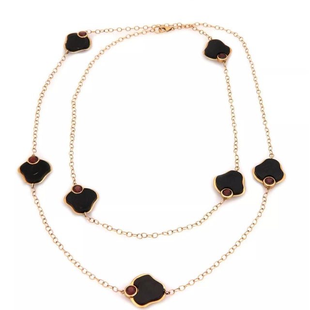 This long sophisticated designer necklace is crafted from 14k yellow gold featuring 2.5mm oval link chain with 7 lotus...