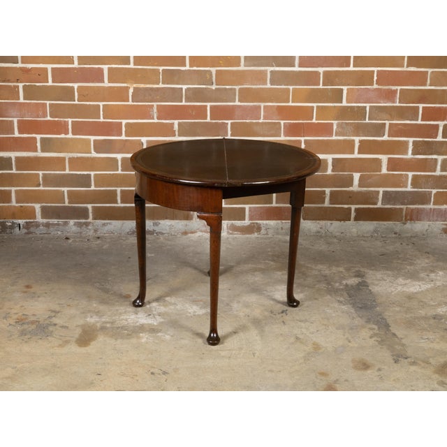 An English Georgian period demi-lune console table from the early 19th century, with flip top, leather inset and gilt...
