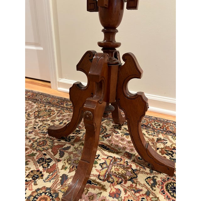 Antique-style circular pedestal wine table featuring an intricate multi-wood floral marquetry top with a radial petal...