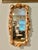 This vintage wall mirror is framed with an abundant arrangement of natural seashells in warm ivory, blush, peach, and...