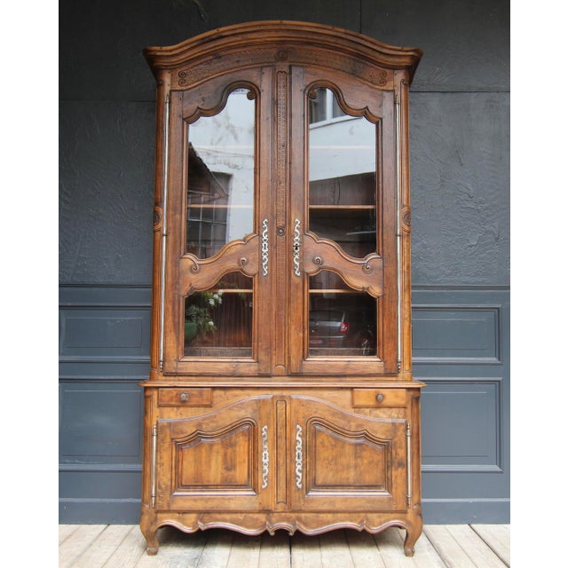 A large French provincial buffet à deux corps from the early 19th century. Louis XV style. Solidly crafted in walnut. Two-...