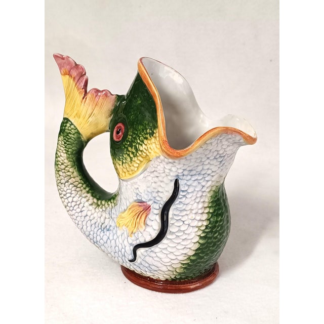 Polychrome ceramic jug in the shape of a fish. The vertical position of the ceramic and the wide mouth opening also allow...