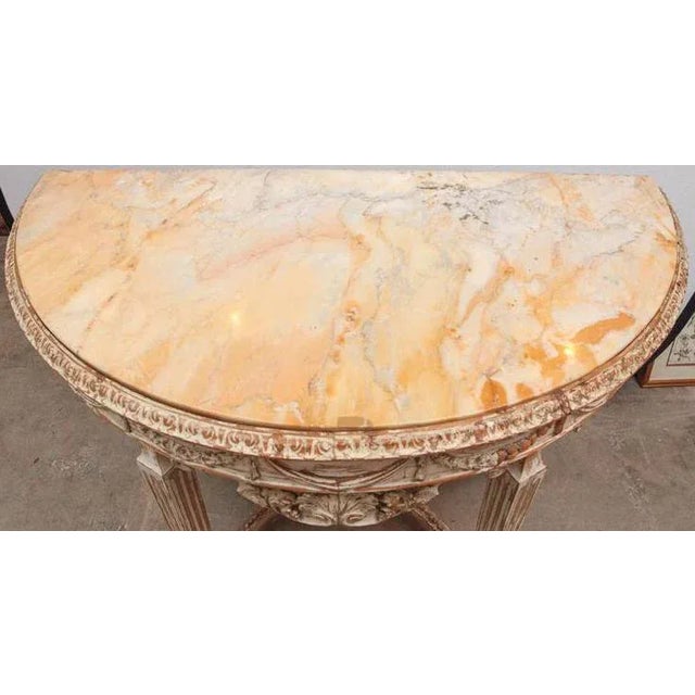 Early 19th century Italian carved demilune console table with stretcher and finely carved shell and garland motif. The...