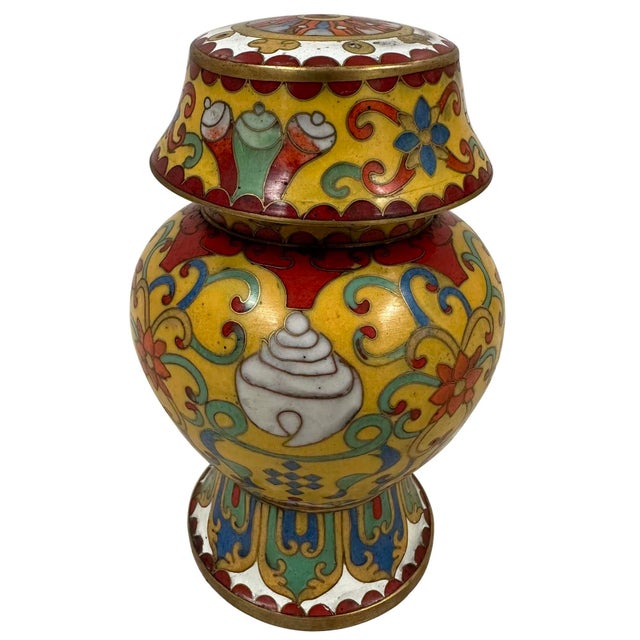 This pair of Chinese cloisonné lidded ginger jars featuring traditional Buddhist decorative symbols on a vibrant yellow...