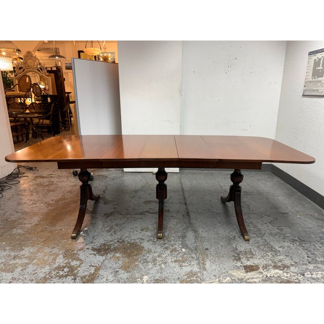 Design Plus Gallery presents a Drop Leaf Dining Table in the style of Duncan Phyfe. This wood dining table presents a...