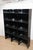 Vintage bookcase composed of three modules in deep black acrylic glass, accented by delicate transparent shelves and...