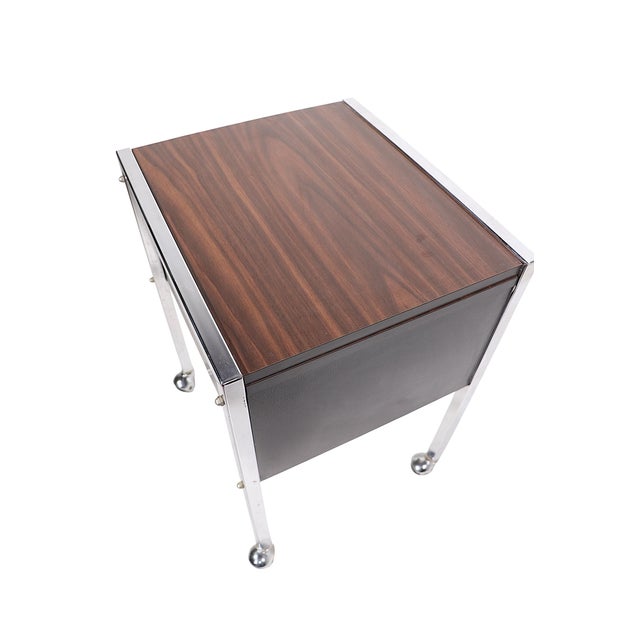Chic rolling cart, side table stand, featuring a faux wood formica top, supported by a squared chrome frame, with black...