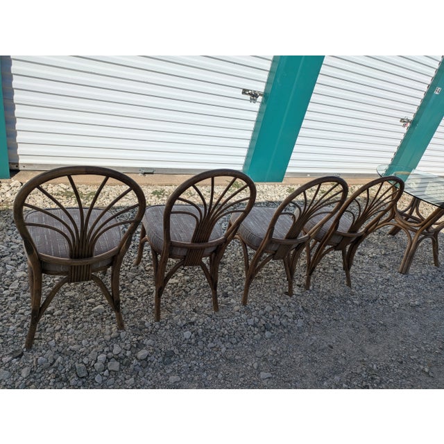 Rattan/bamboo dining table with glass top. Four rattan/bamboo chairs come with the table. Glass top is in good condition.