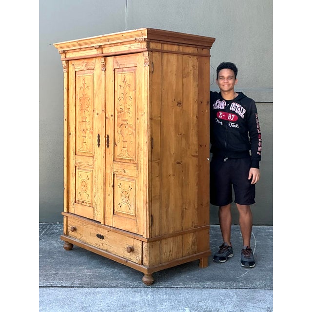 This stately antique Austrian armoire is a masterclass in European provincial craftsmanship, blending rustic warmth with...